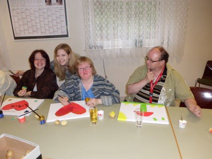 Foto: Seniorinnen sitzen am Tisch, essen Kuchen, lachen und unterhalten sich.