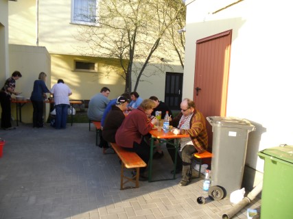 Foto: Eine Gruppe von Senioren - aufgreiht vor einer DRK-Fahne - schauen lächend in die Kamera.